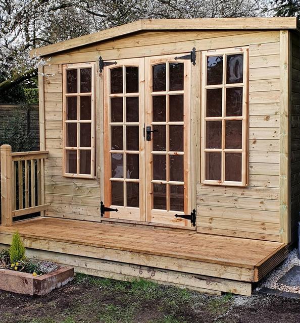 Timber summerhouse with double doors on a deck
