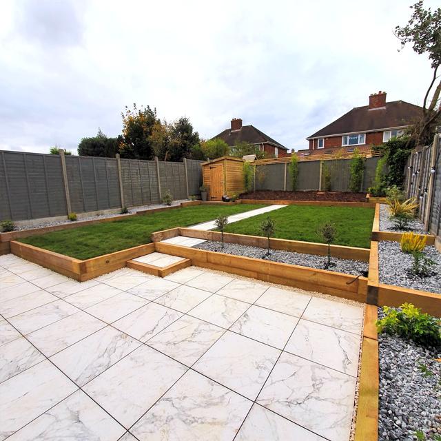 Porcelain patio with raised sleeper beds and new lawn