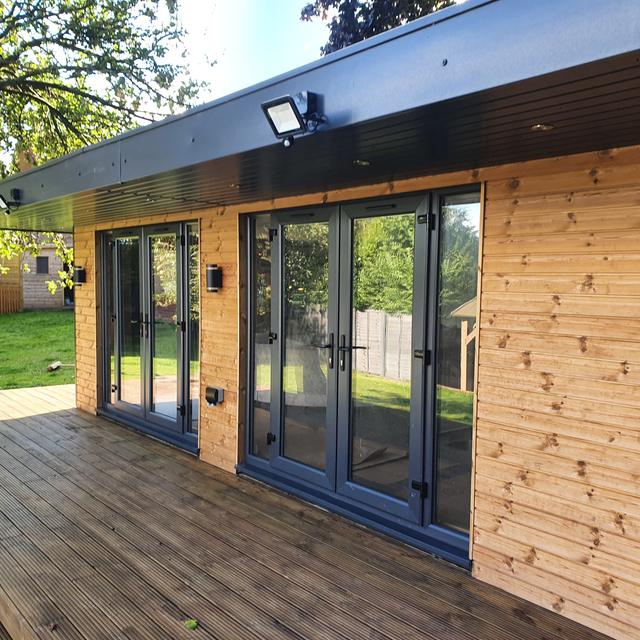 Bespoke timber-clad garden room with bi-fold doors and deck